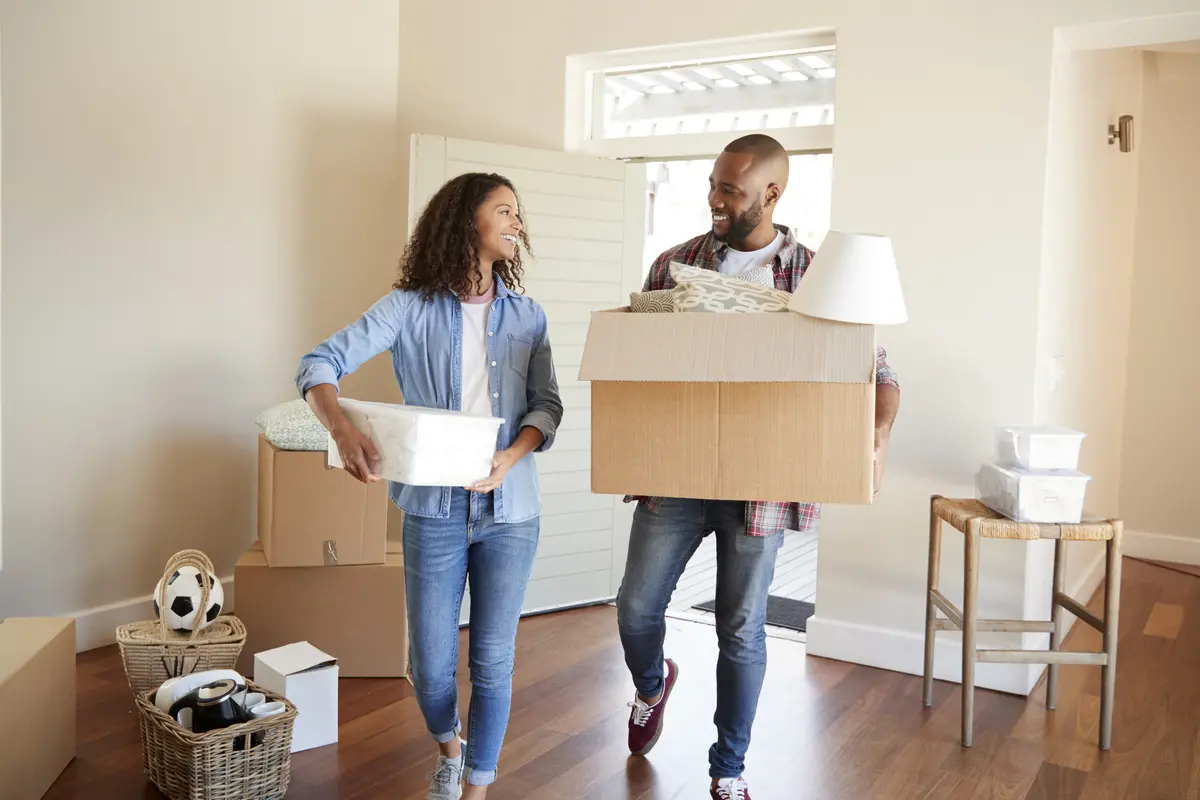 Couple Carrying Boxes Into New Home On Moving Day