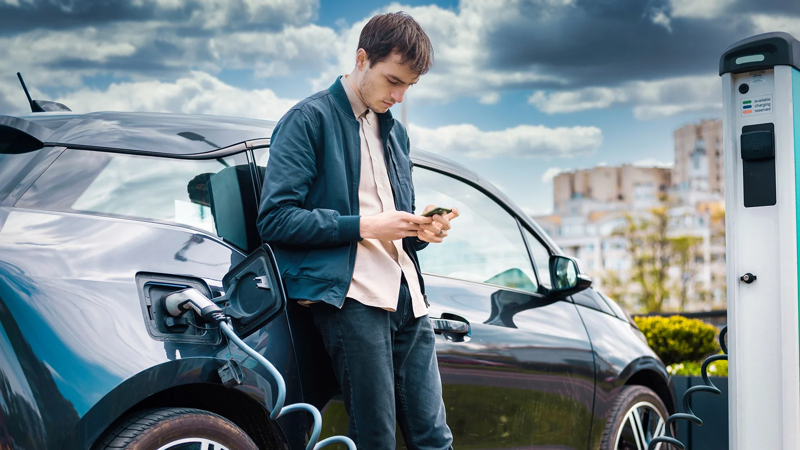 man charging his electric car charge station using smartphone 1